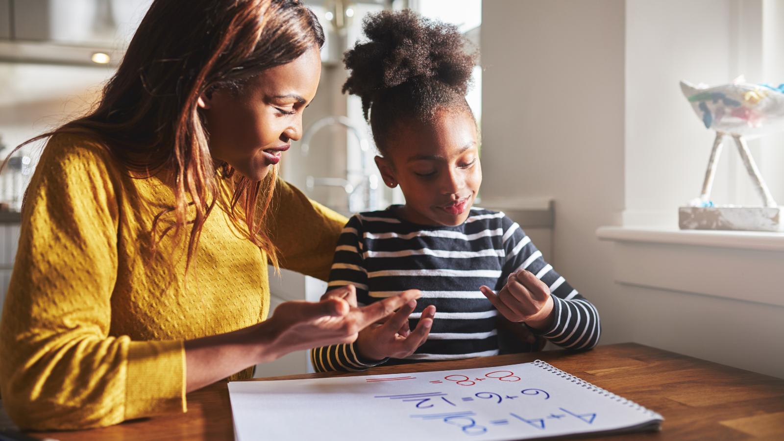 Mother and daughter doing sums at the table together