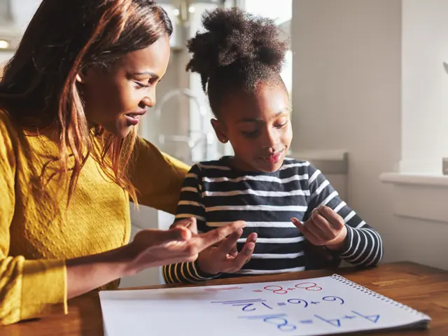 Mother and daughter doing sums at the table together