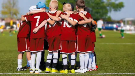 A group of children in a football huddle