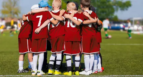 A group of children in a football huddle