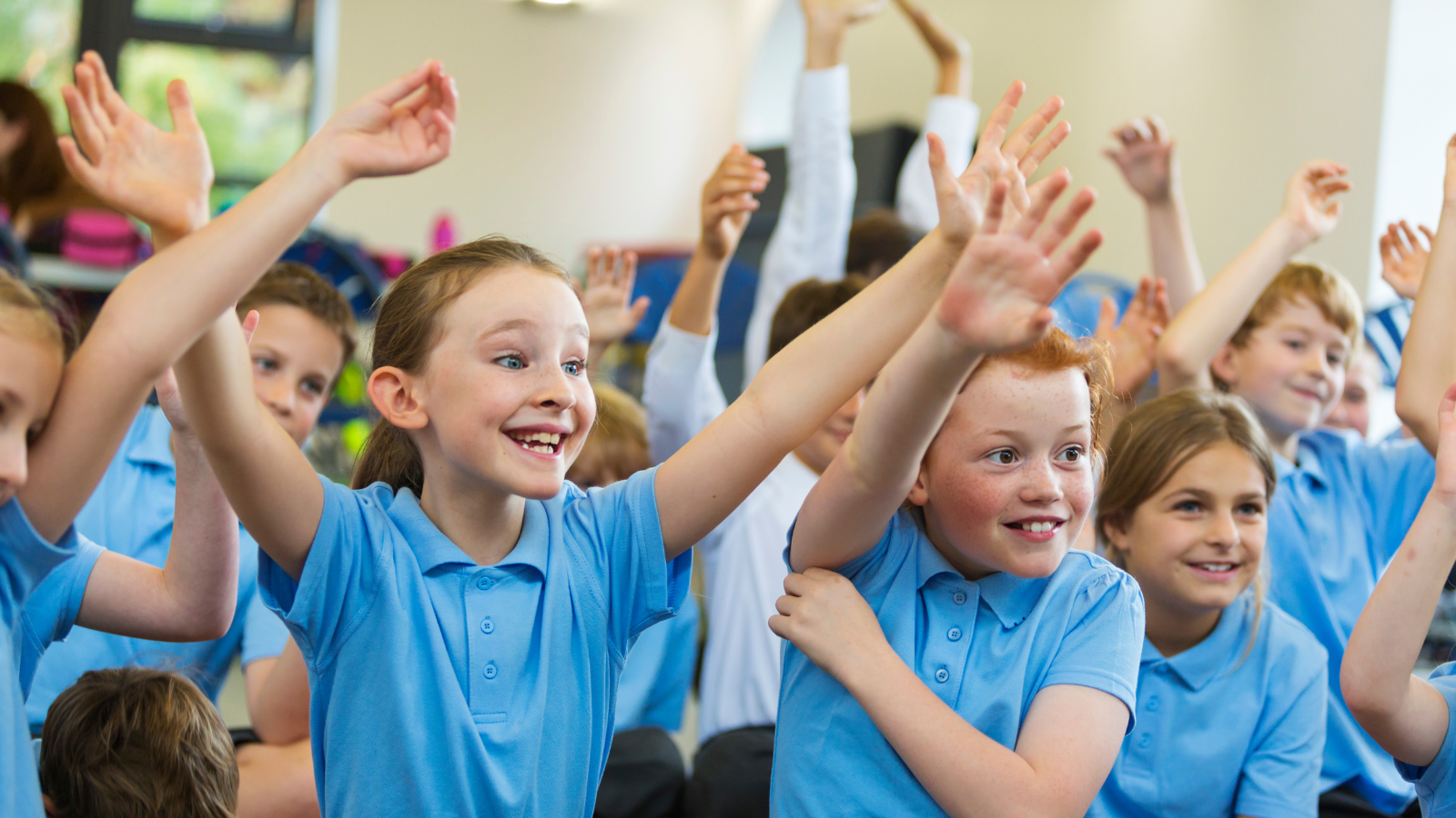 A group of children looking happy in an assembly