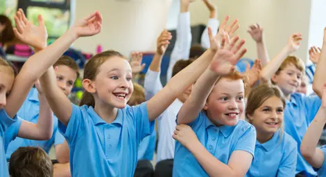 A group of children looking happy in an assembly