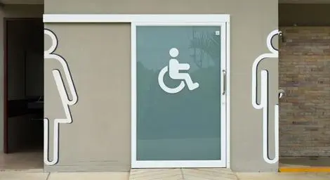 An accessible toilet between two other public toilets