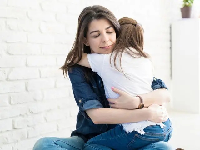 Mother hugging daughter