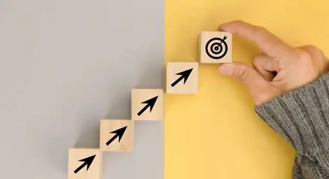 Wooden blocks with arrows on leading to another block with a target on