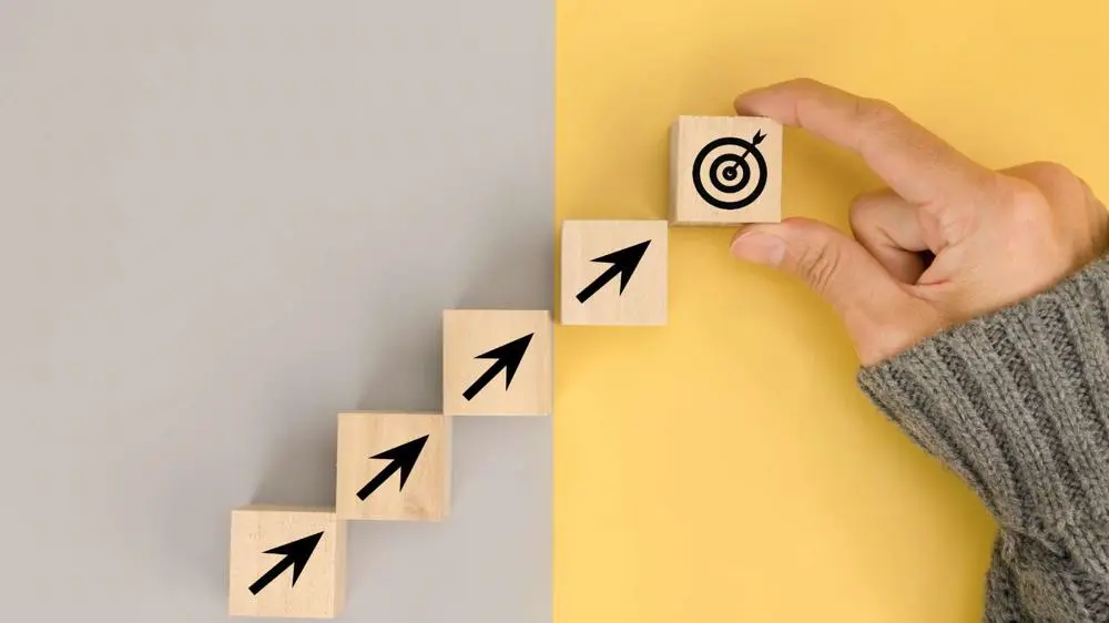 Wooden blocks with arrows leading to a target